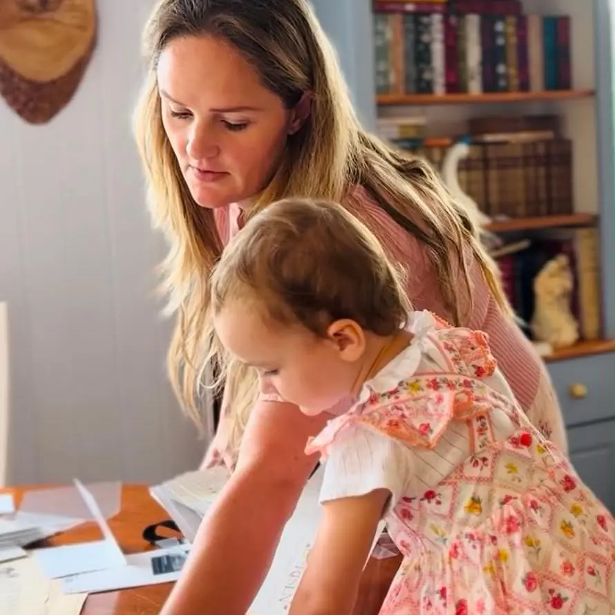 Ella at her desk with her toddler daughter, looking over papers together