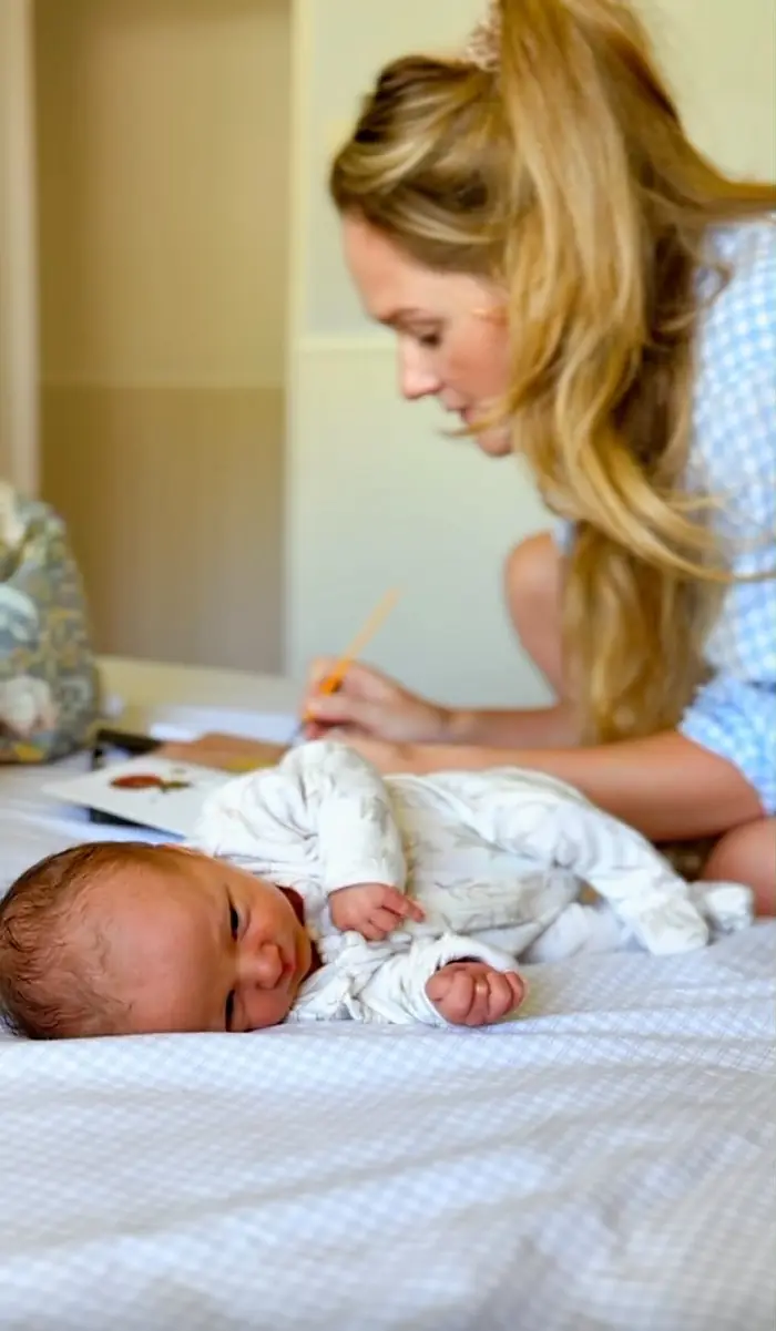 Ella working beside her sleeping newborn baby