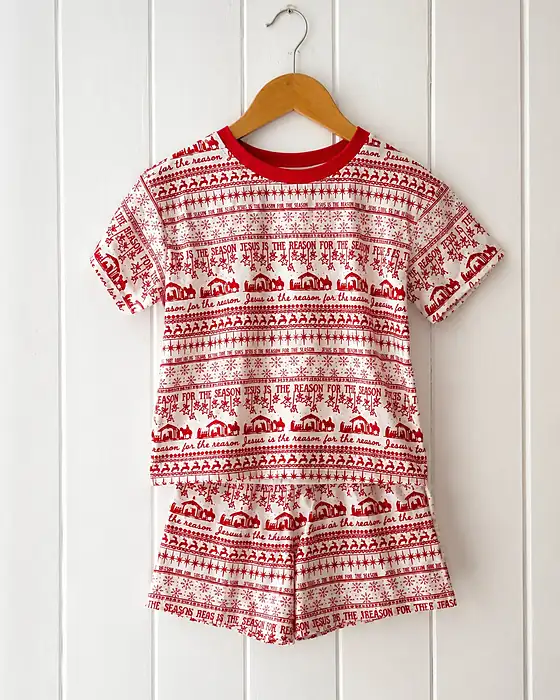 The red and white Jesus is the Reason children's pyjama set on a hanger